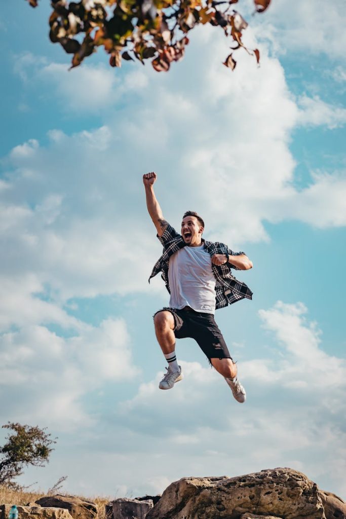 A vibrant image of a young man jumping with joy outdoors, capturing a moment of freedom and exhilaration.
